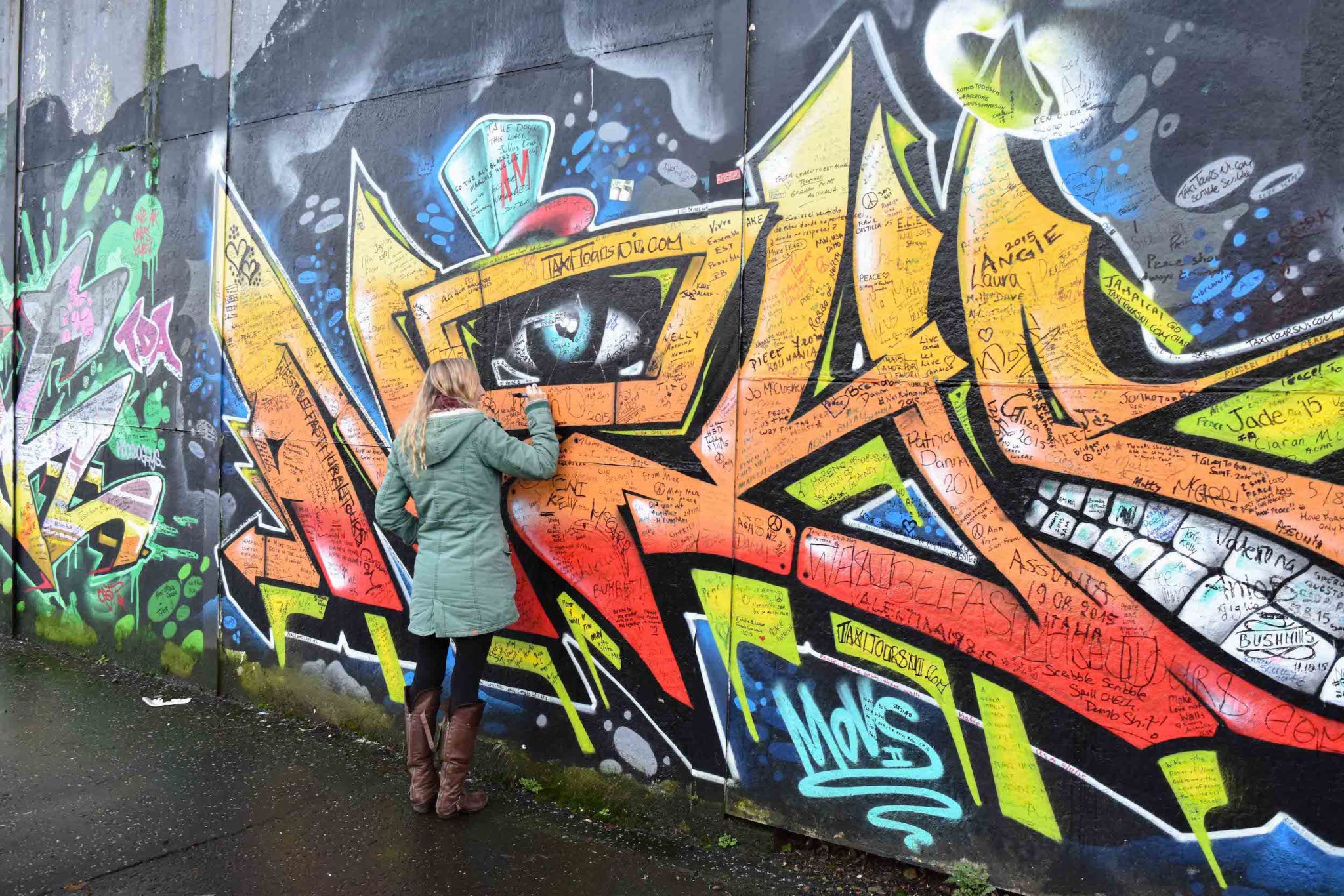 Hayley writing on the peace wall in Belfast