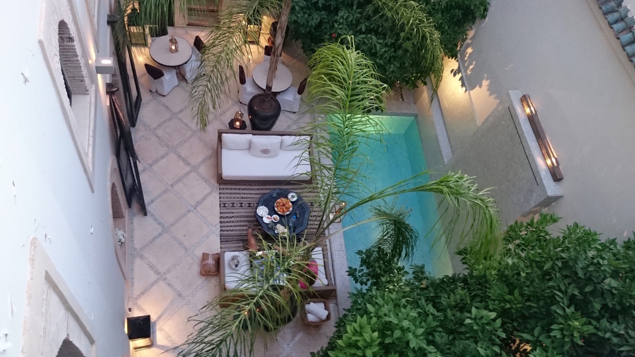 An aerial view of a riad courtyard with a pool
