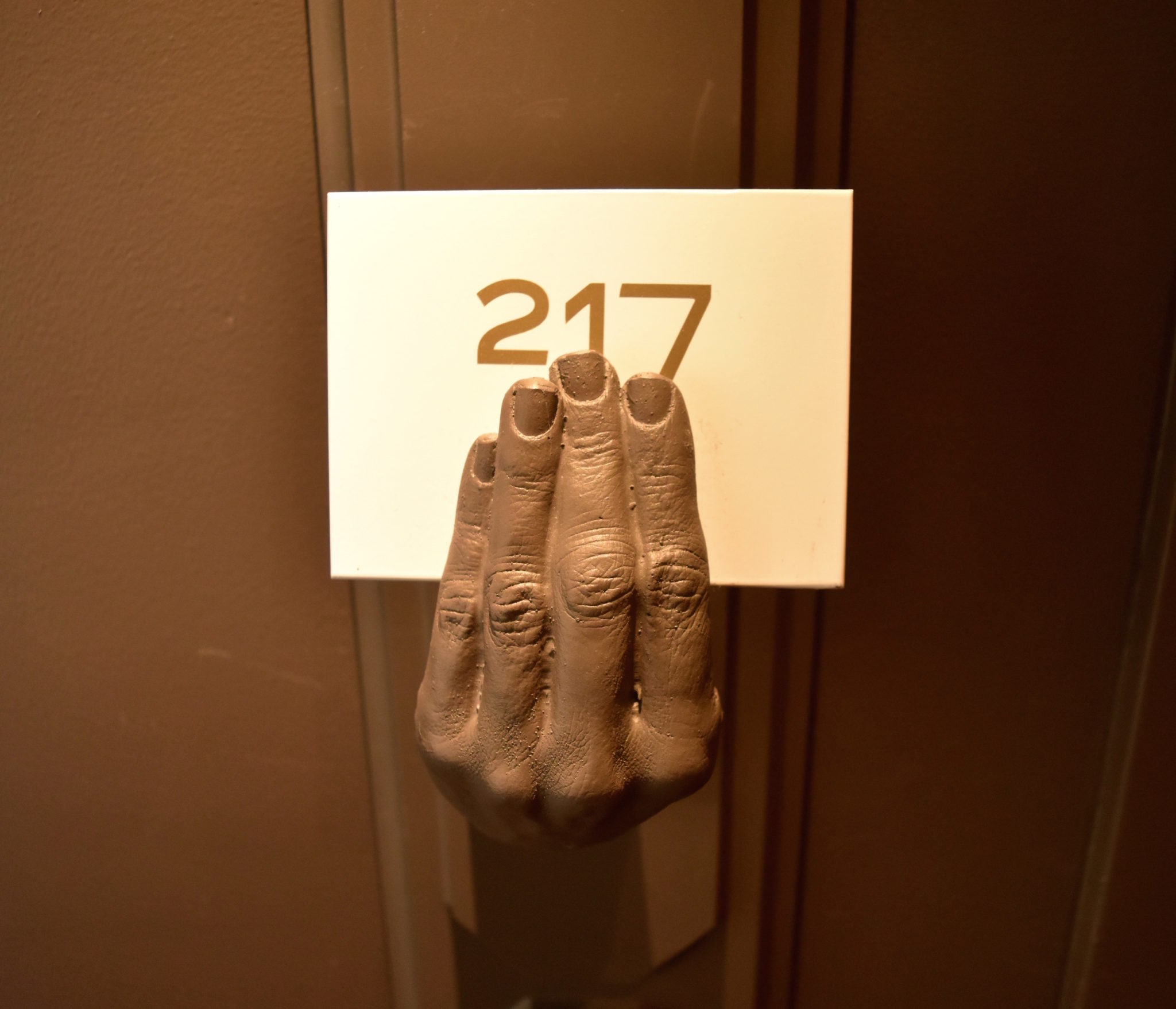 A hand sculpture holding a door number