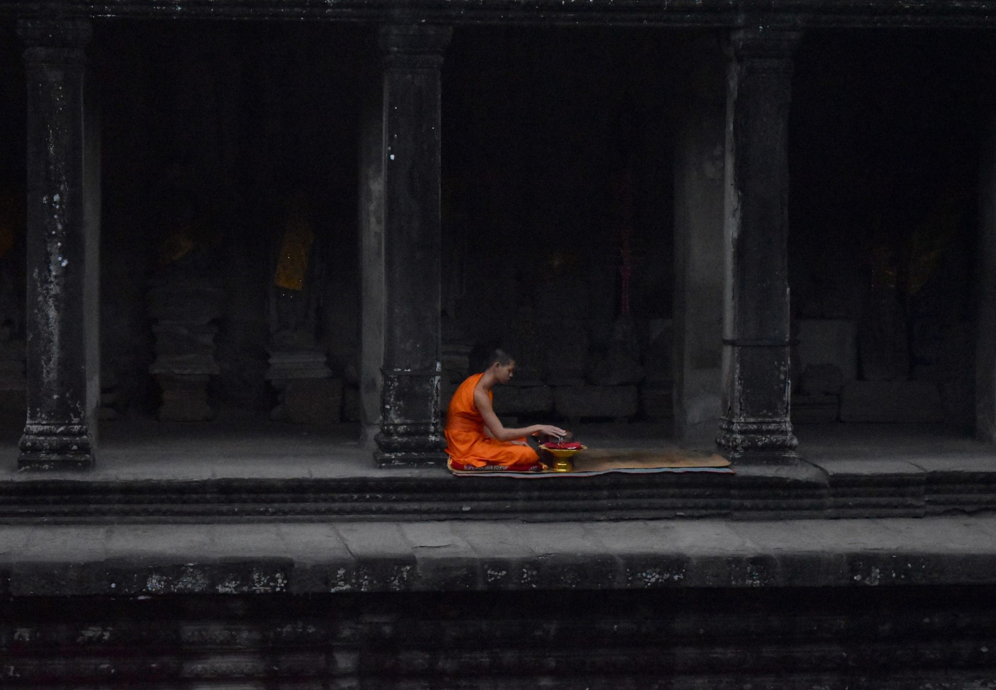 A monk sitting at Angkor Wat