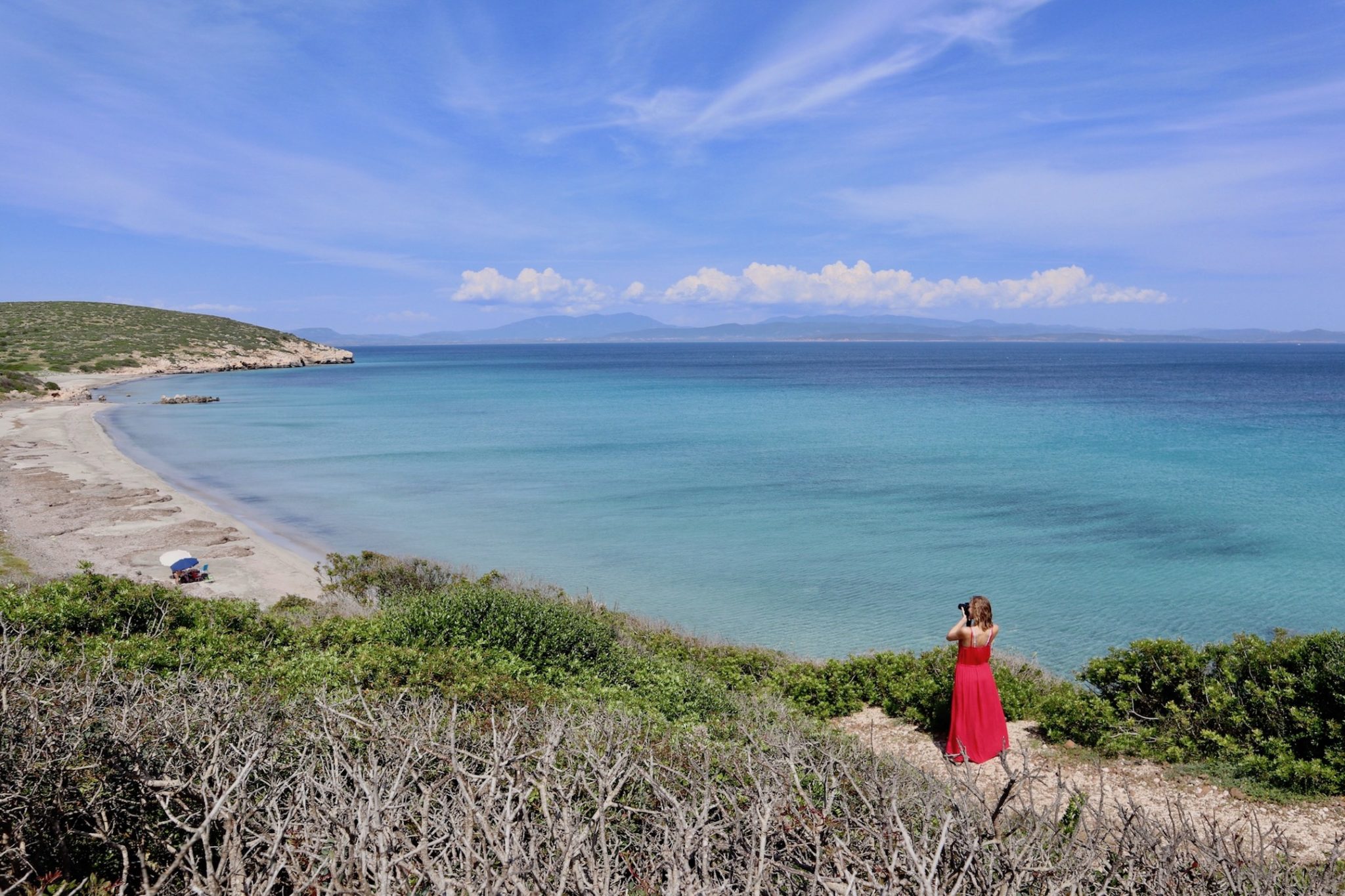 Hayley taking a photo of a beach in Sardinia