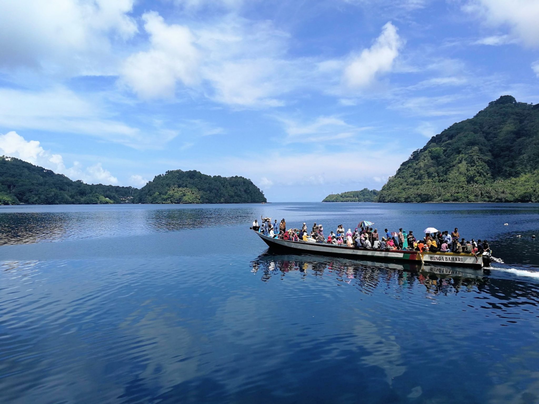 People travelling on a boat between lush Indonesian islands 