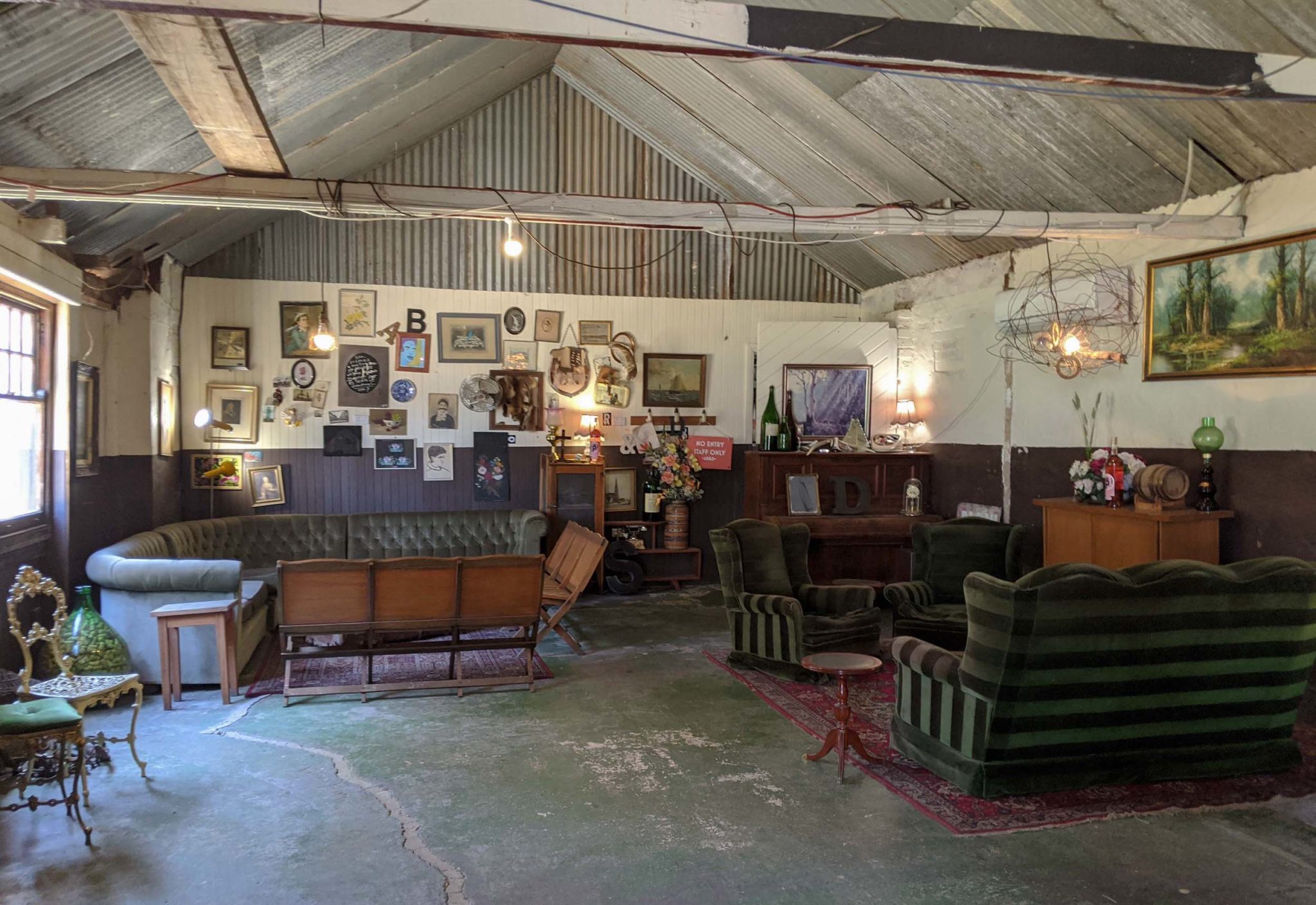 Antique furniture and crowded artwork and frames inside the cellar door