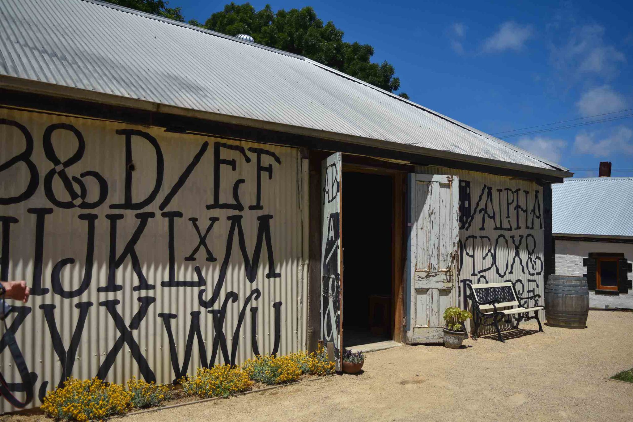 A corrugated iron building covered in letters at Alpha Box and Dice winery 