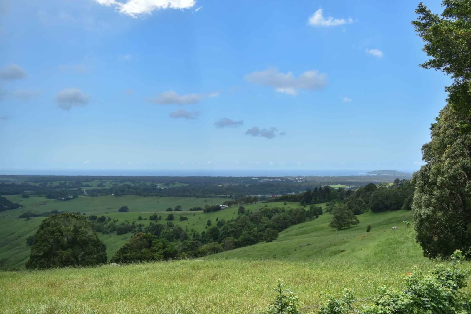 A view of green fields and ocean in the distance 